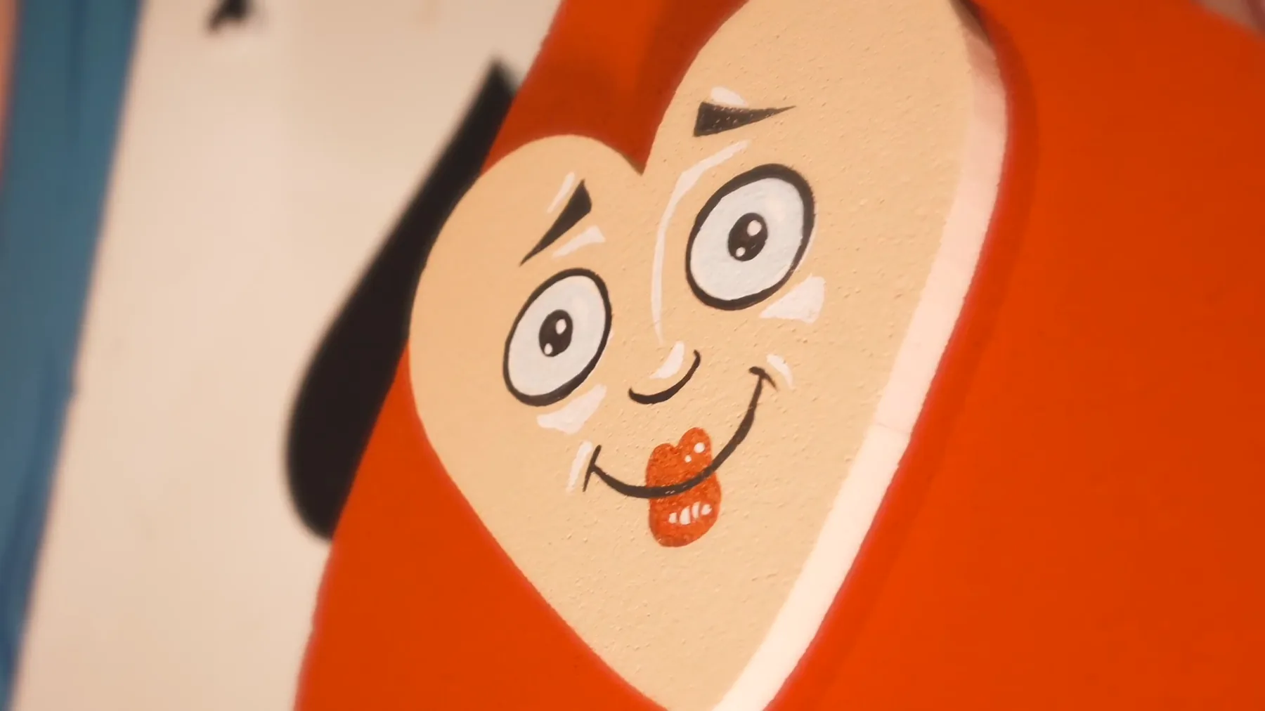 Da vicino, il volto sorridente disegnato su una carta da gioco rossa a forma di cuore
