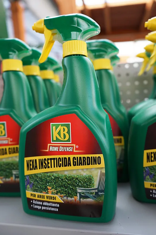 Flaconi spray di insetticida da giardino in fila, con il tappo verde e giallo