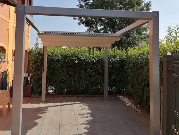 Dopo: pergola grigia sulla pavimentazione nuova, davanti alla siepe alta