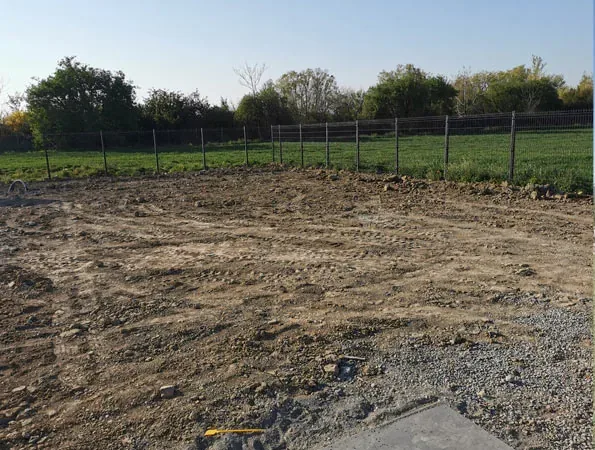 Prima: terreno spoglio e livellato, con la recinzione e gli alberi sul fondo