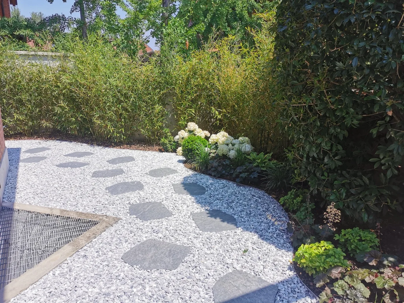 Camminamento in pietra nel prato di un giardino realizzato da Sinflora