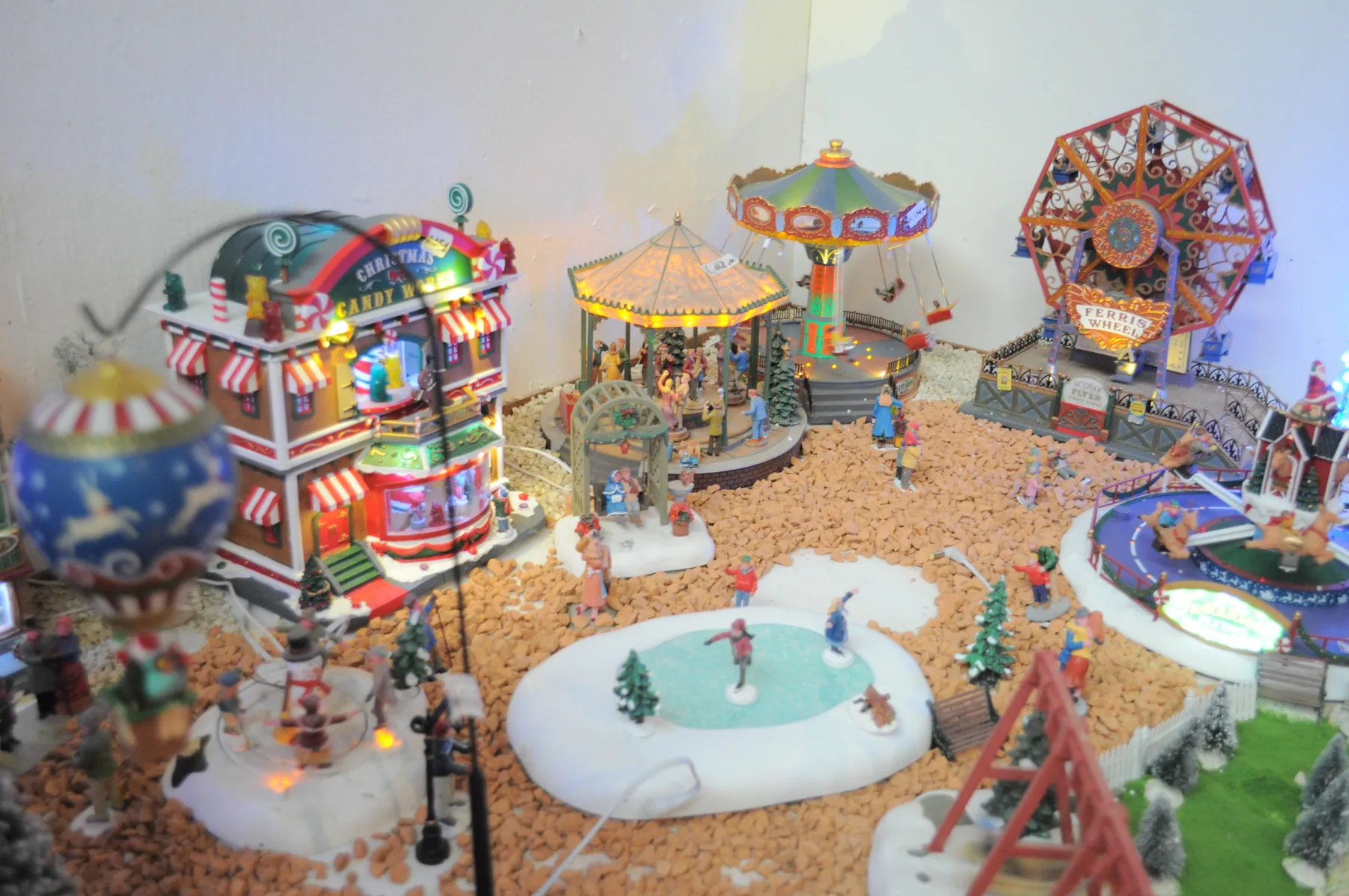 Luna park in miniatura con la ruota panoramica, le giostre e una pista di pattinaggio