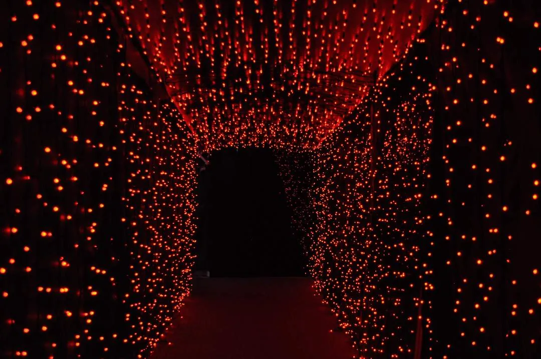 Tunnel di luci rosse che si stringe verso il fondo buio