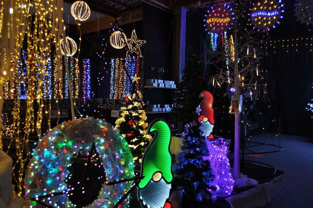 Reparto luci con cascate dorate, sfere luminose, uno gnomo di luce verde e una ghirlanda multicolore