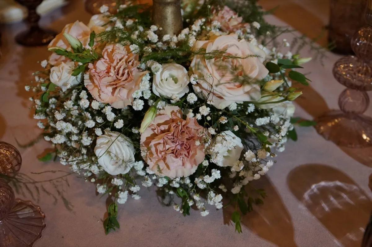 Centrotavola rotondo di rose rosa e bianche con la gypsophila, visto dall'alto